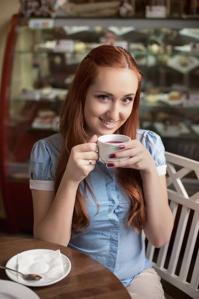 Genç ve güzel kadın bir restoranda bir masada oturmuş çay içme — Stok fotoğraf