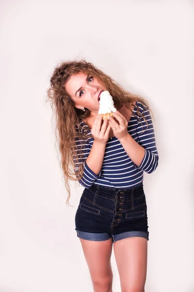 Vacker glad ung kvinna äta kakan över vit bakgrund — Stockfoto