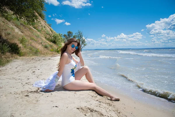 漂亮的小女孩坐在海滩上放松 穿着白色泳衣的女人夏季生活方式 — 图库照片