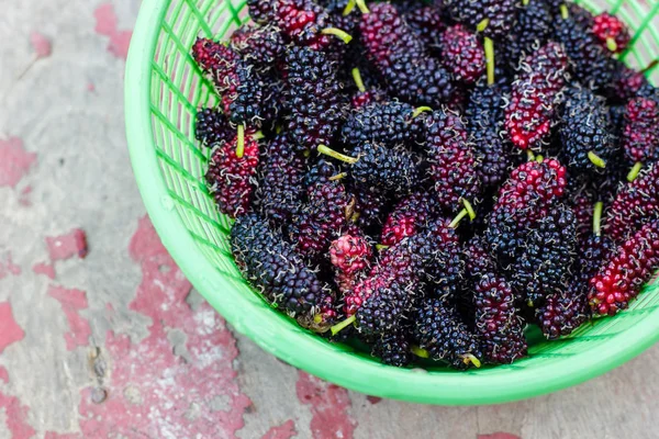 Mulberry i korg på trä bakgrund — Stockfoto