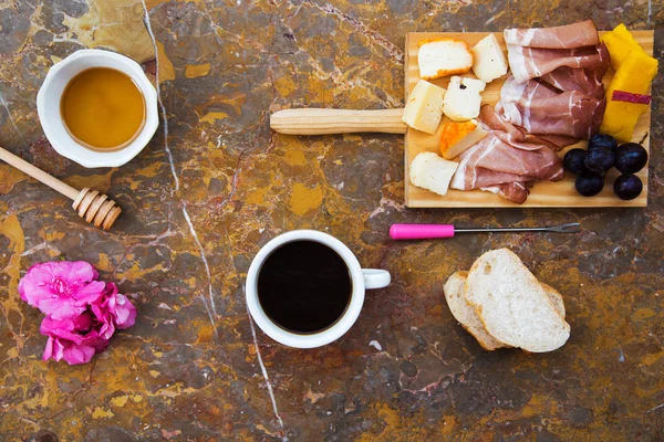 Colazione sulla superficie di marmo. Vista dall'alto. Prosciutto, formaggio, frutta, miele . — Foto Stock