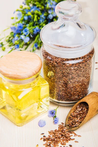 Linseed oil, flax seeds, and flowers on a light background. — Stock Photo, Image