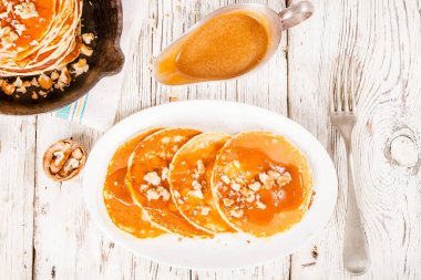 Karamel ve eski bir ahşap zemin üzerine fındık ile krep.