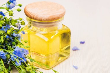 Keten tohumu yağı, keten tohumu ve açık renkli çiçekler.