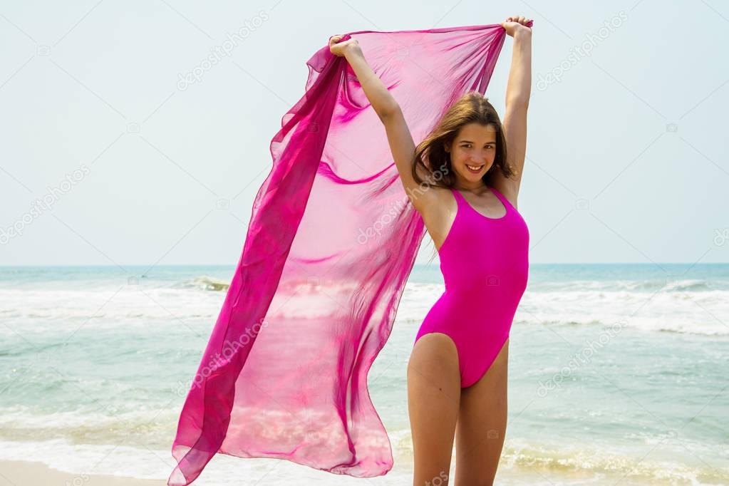 Sport girl-teenager in a pink bathing suit on background of ocean. Atlantic ocean. Porto, Portugal
