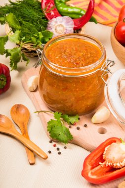 Domates sos (ketçap, adzhika) ve sebze bej bir tablo. Ev koruma.