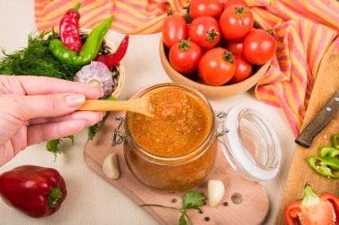 Domates sos (ketçap, adzhika) ve sebze bej bir tablo. Ev koruma.