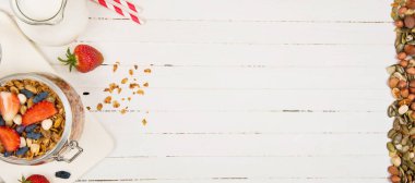 ev yapımı granola beyaz bir tabloda bir cam kavanoza. Sağlıklı gıda.