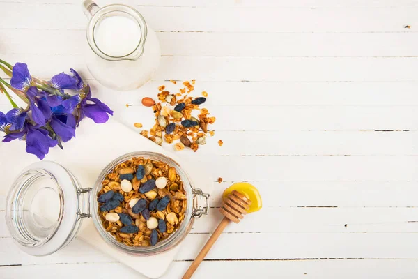 ev yapımı granola beyaz bir tabloda bir cam kavanoza. Sağlıklı gıda.