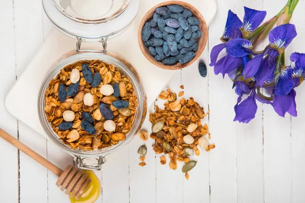 Zelfgemaakte muesli in een glazen pot op een witte tafel. Gezonde voeding. — Stockfoto