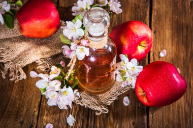 Bir şişe elma sirkesi (elma şarabı), taze elma ve elma ağacı çiçek ahşap arka plan üzerinde. Ülke stil.