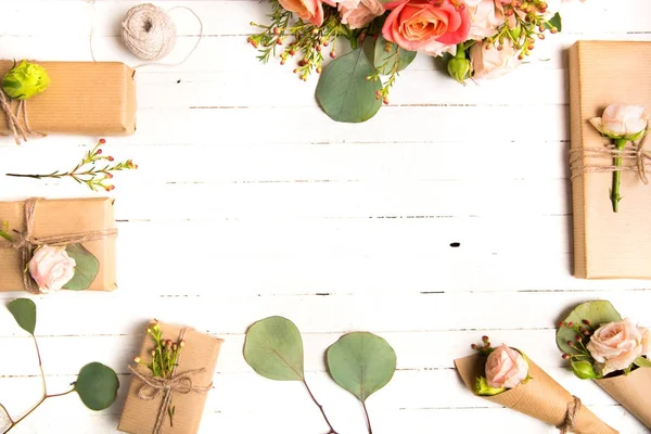 Blütenkomposition. Blumen und Geschenke auf weißem Hintergrund. flache Lage, Draufsicht. — Stockfoto
