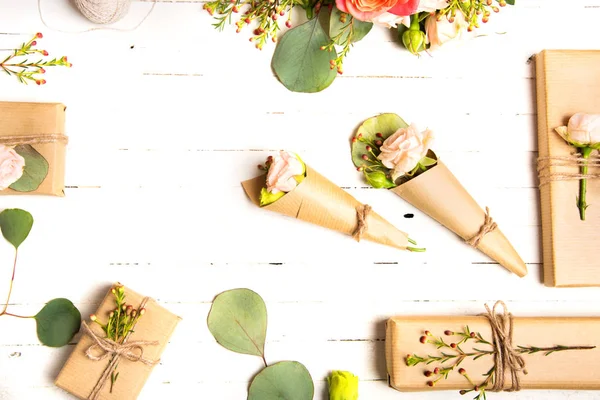 Blütenkomposition. Blumen und Geschenke auf weißem Hintergrund. flache Lage, Draufsicht. — Stockfoto