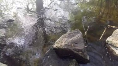 Su nehir içinde taşlar yıkar