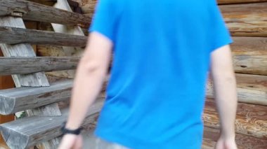 Genç bir adam bir ahşap merdiven tırmanıyor