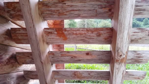 Молодой человек спускается по деревянной лестнице — стоковое видео