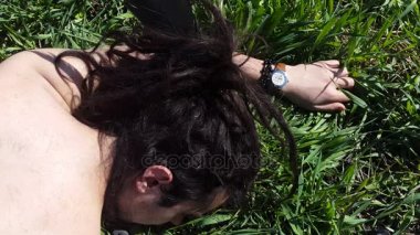 Beyaz adam yüz çimen hareket etmeden yatan dreadlocks ile. 