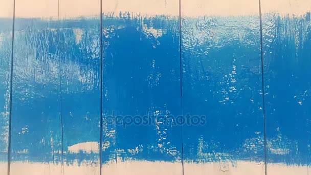 Feliz año nuevo en una tabla de madera aparece debajo de una capa de pintura azul — Vídeos de Stock