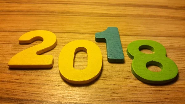 Дерев'яні оливкові номери, що формують номер 2018 року, На новий рік 2018 на дерев'яному тлі . — стокове фото