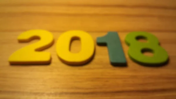 Houten olored getallen vormen het nummer 2018, voor het nieuwe jaar 2018 op een houten achtergrond. — Stockfoto
