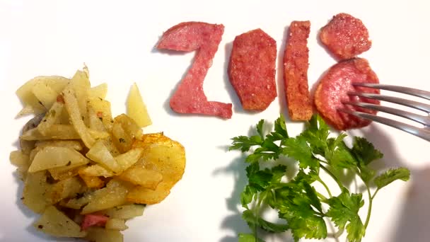 Колбаса в виде номера 2018 с жареным картофелем и петрушкой на белой тарелке — стоковое видео