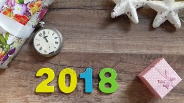 Gece yarısı - yeni yıl yılbaşı süsleri ve hediyeleri ile ahşap bir masa üzerinde eski saat. Timelapse