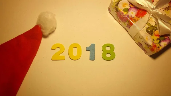 Chiffres colorés pour former le nombre 2018 sur toile blanche avec des cadeaux de Noël — Photo