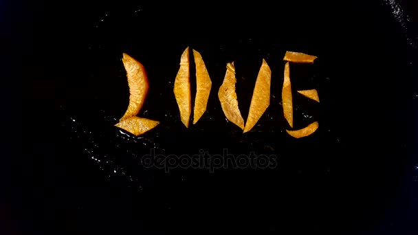 Bak wortelen in de vorm van het woord "love" in een koekenpan — Stockvideo