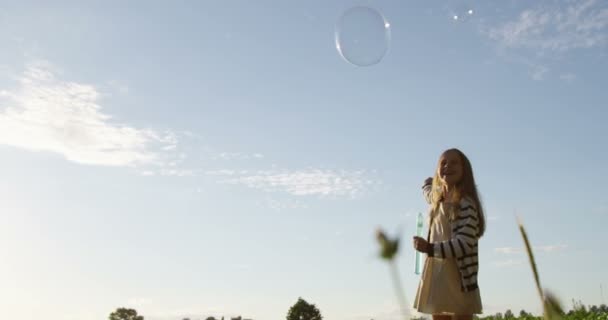 Gelukkig klein meisje met lucht bubbels spelen buiten in Slow Motion — Stockvideo