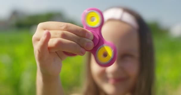 Gros plan de fille souriante jouant avec Spinner sur le terrain le jour ensoleillé 