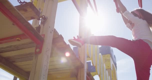 Jouer fille sur aire de jeux avec des drapeaux de soleil — Video