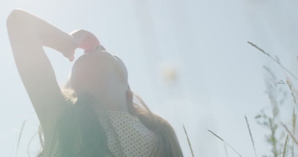 Niña divirtiéndose con Gadget Spinner sentado en hierba verde — Vídeo de stock