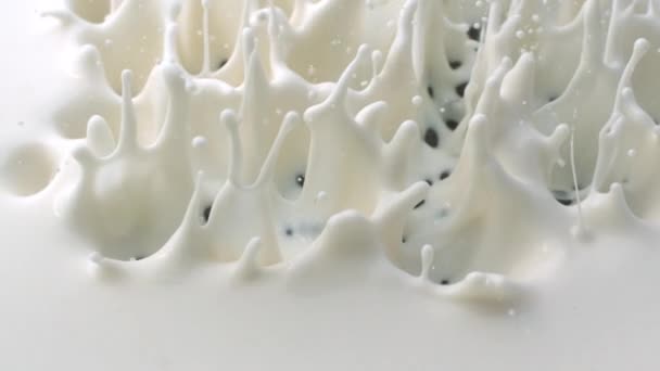 Pezzi di cioccolato che cadono nella crema bianca con schizzi — Video Stock