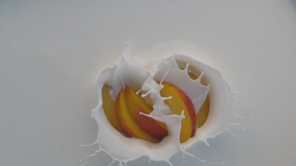 Всплески йогурта с персиком, падающим вниз — стоковое видео
