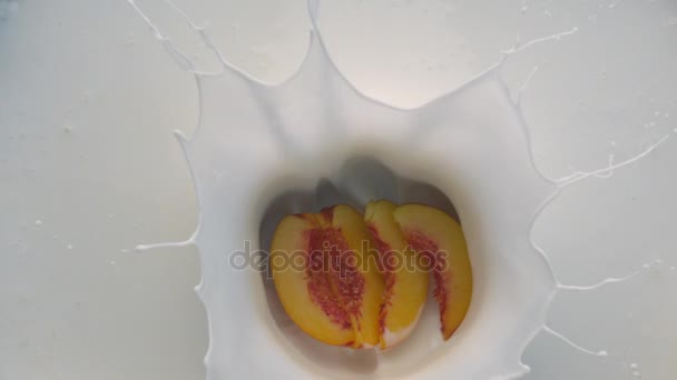 Weißer Joghurt mit herabfallenden Pfirsichfrüchten — Stockvideo