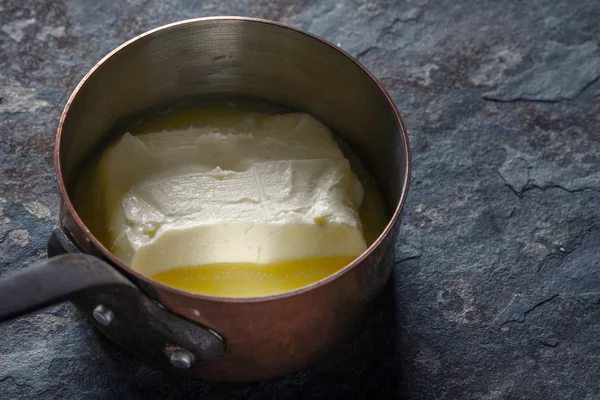 Smält smör i STEKGRYTA på sten bakgrunden horisontella — Stockfoto