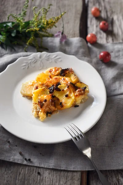 Tartiflette on the white plate on the wooden table vertical — Stock Photo, Image