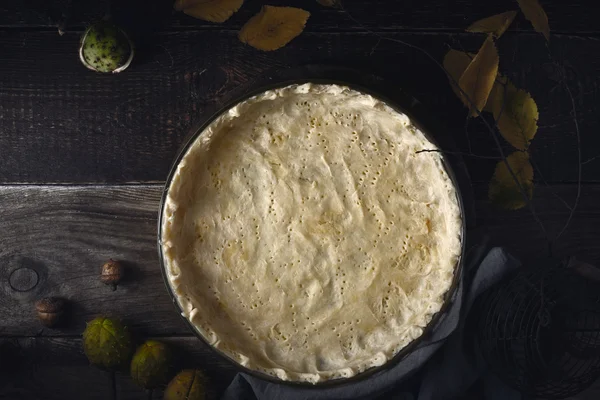 Pastelaria cru shortcrust na assadeira na vista superior da mesa de madeira — Fotografia de Stock