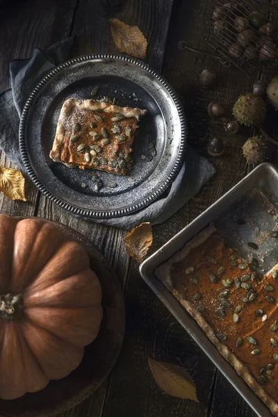 秋のギフトと木製のテーブル上の金属板にカボチャのパイのスライス — ストック写真