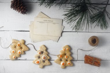 Garland Noel kurabiyeleri ve kartpostal Beyaz ahşap zemin üst görüntüleme