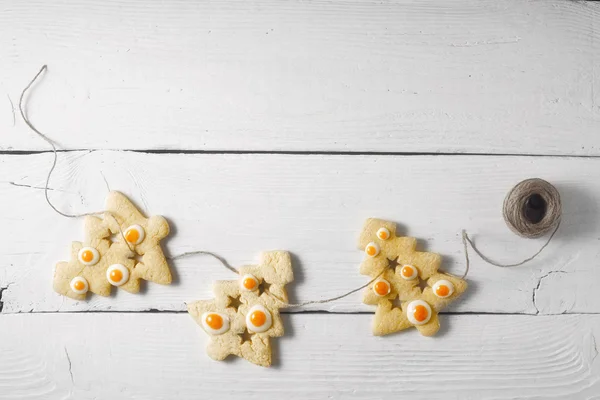 Girlanda z Christmas cookies na górze białe drewniane tła Zobacz — Zdjęcie stockowe