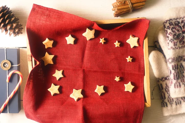 Biscoitos de Natal no guardanapo vermelho na bandeja com diferentes acessórios vista superior — Fotografia de Stock