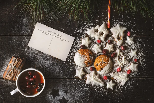Ahşap arka plan kartpostal ve berry çay ile çerezleri tarafından yapılan Noel top