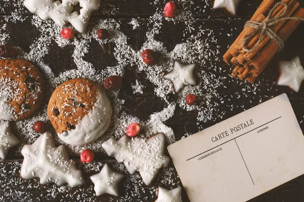 Christmas cookies with postcard and cinnamon on the wooden background — Stock Photo, Image