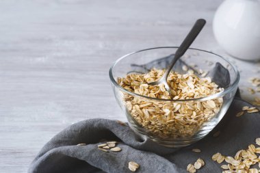 Ahşap masa üzerinde bir cam kapta yulaf gevreği