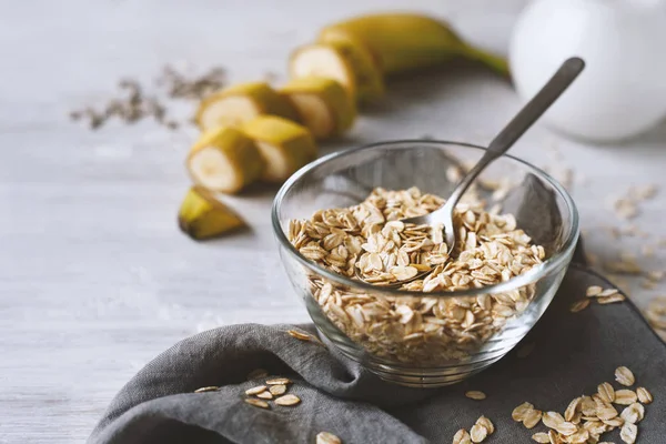 Copos de avena en un recipiente de vidrio sobre la mesa de madera — Foto de Stock