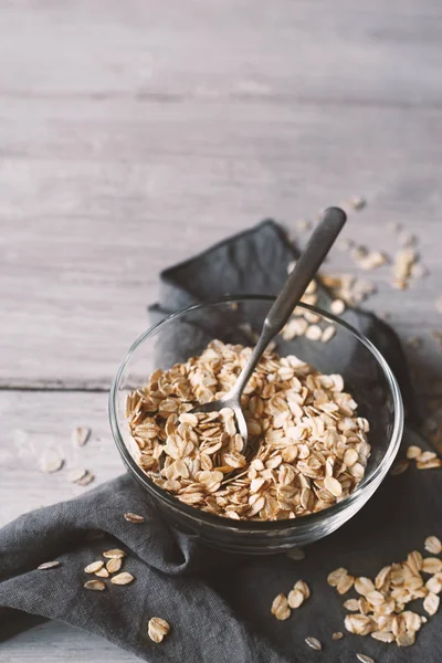 Oat flakes in a glass bowl on the wooden table — Stock Photo, Image