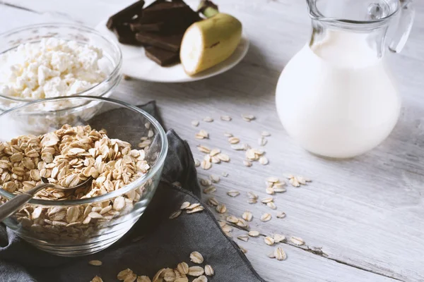 Oat flakes in a glass bowl on the wooden table — Stock Photo, Image