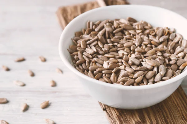 White ceramic bowl with sunflower seeds — Stock Photo, Image