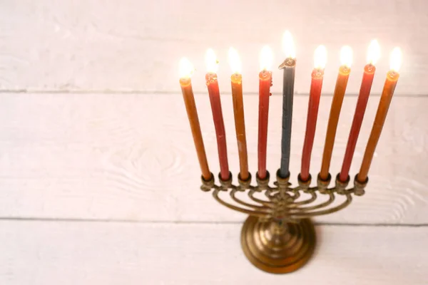 Hanukkah menorah con velas encendidas en la mesa de madera blanca horizontal —  Fotos de Stock